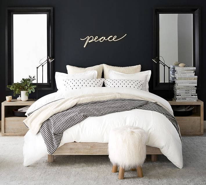 a bedroom with black walls and white bedding