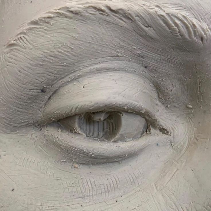 an eye is shown in the center of a sculpture that looks like it's made out of clay