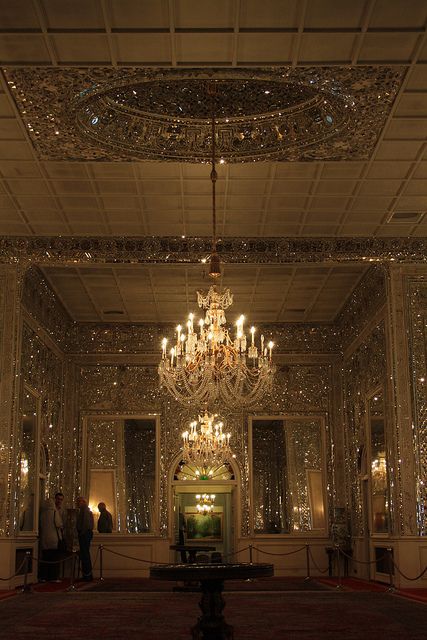 a chandelier hanging from the ceiling in a fancy room with lights on it