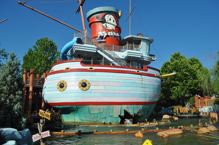 a boat that is sitting in the water near some trees and other things around it