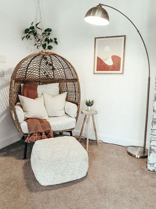 a chair and ottoman in a room with a lamp on the wall next to it