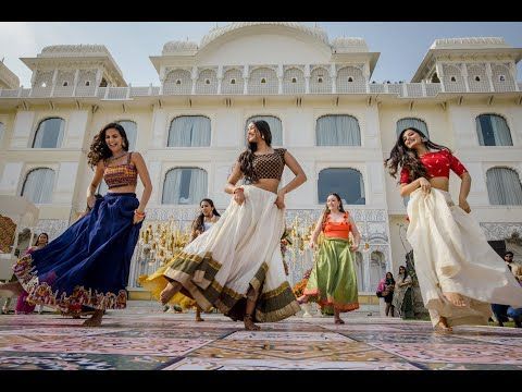 three women are dancing in front of a building