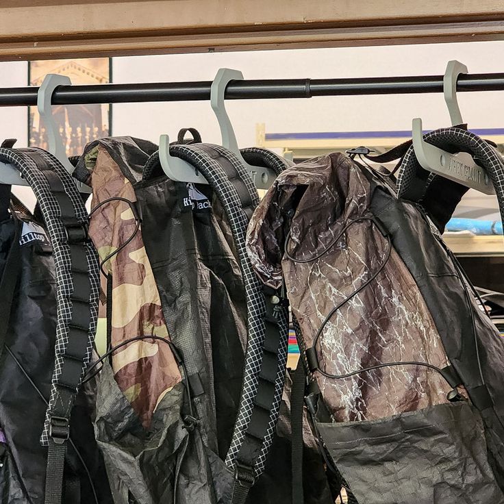 several backpacks are hanging up on a rack