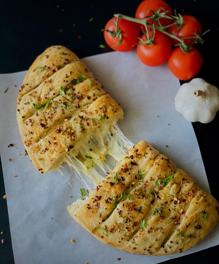 a piece of pizza is being held by a fork with tomatoes and garlic on the side