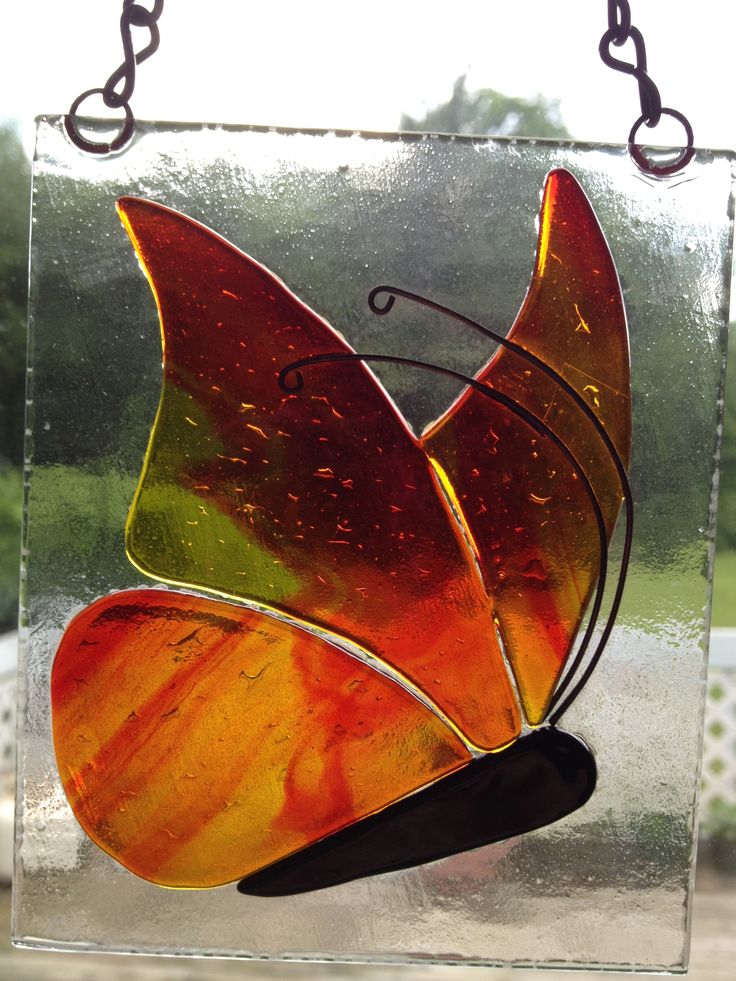 a stained glass butterfly sitting on top of a window