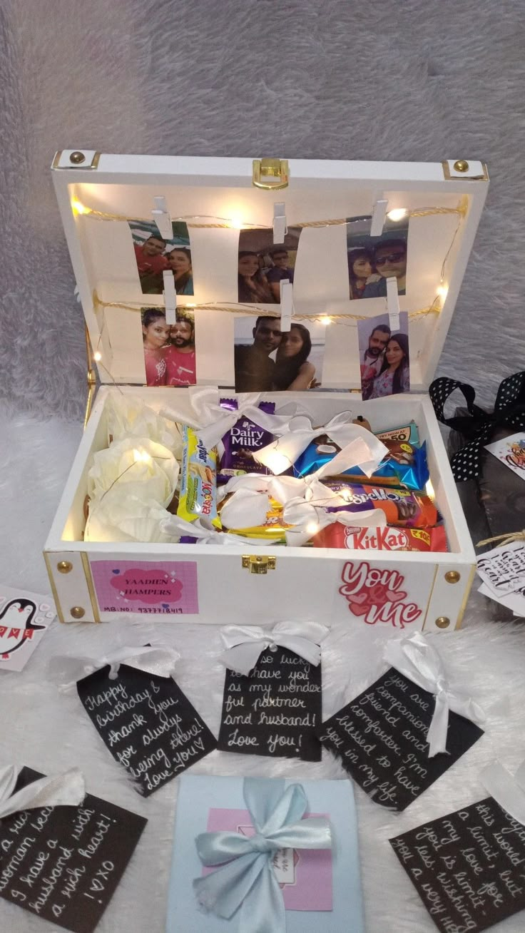 an open suitcase filled with personalized items on top of a white tablecloth covered floor