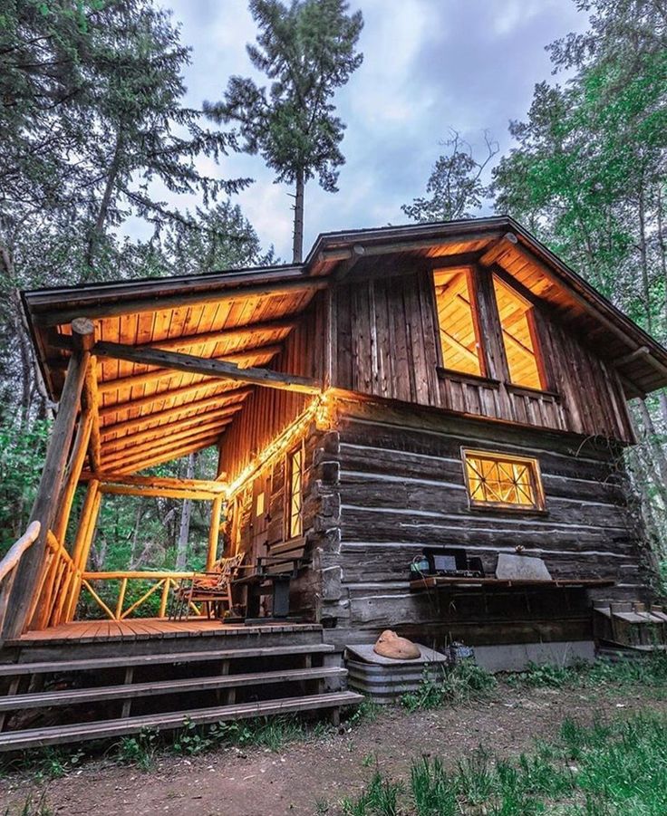 a cabin in the woods is lit up at night