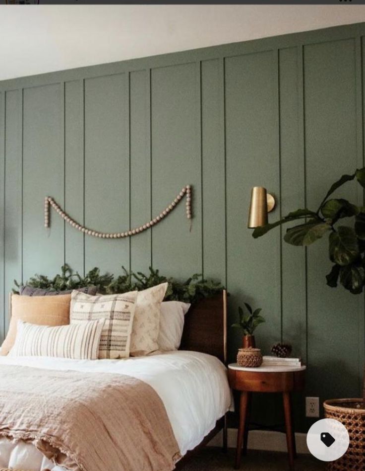 a bed sitting in a bedroom next to a green wall with wooden slats on it