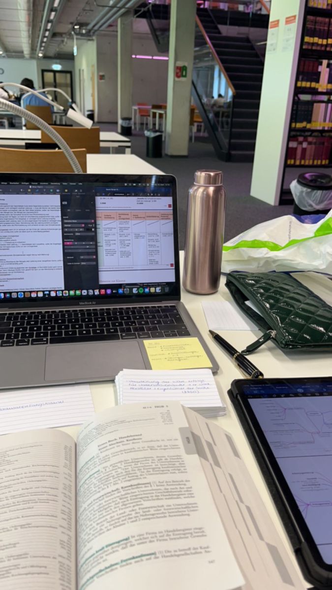 an open book and two laptops on a table