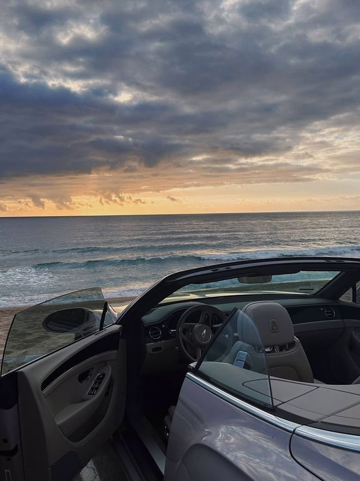 a car parked on the beach next to the ocean