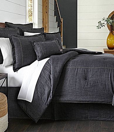 a bed with black and white linens in a bedroom