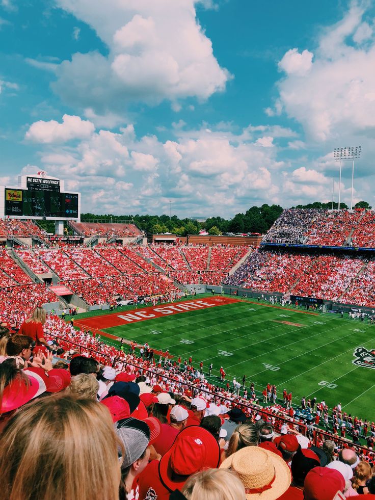 a football stadium filled with lots of red and white people sitting on the bleachers