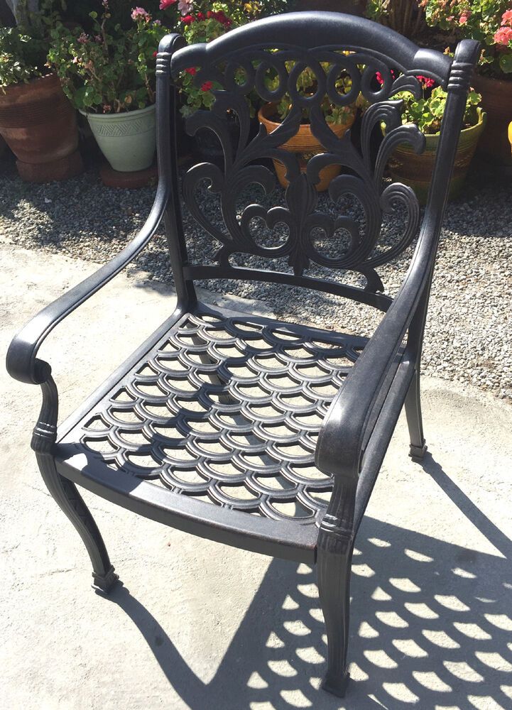 a black metal chair sitting on top of a cement ground