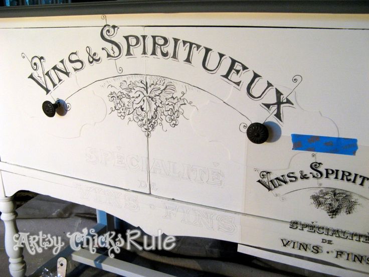 an old dresser has been painted white with black lettering on the front and bottom panel