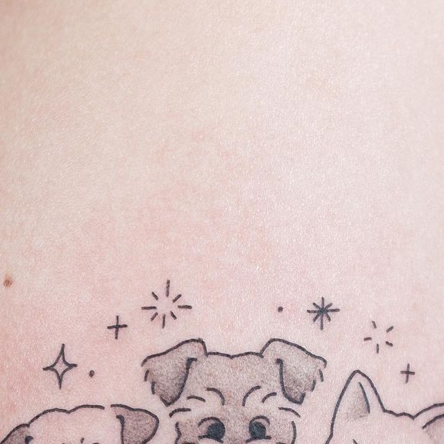 two cats and a dog tattoo on the back of a woman's leg, with stars in the background