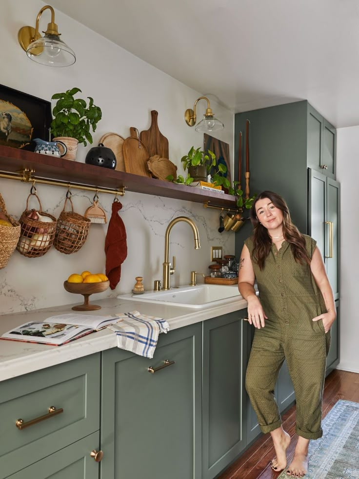 a woman standing in the middle of a kitchen