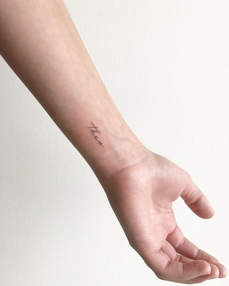 a person's arm with a small tattoo on the left side of their wrist