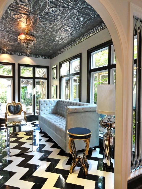 a living room filled with lots of furniture next to large windows and a chandelier