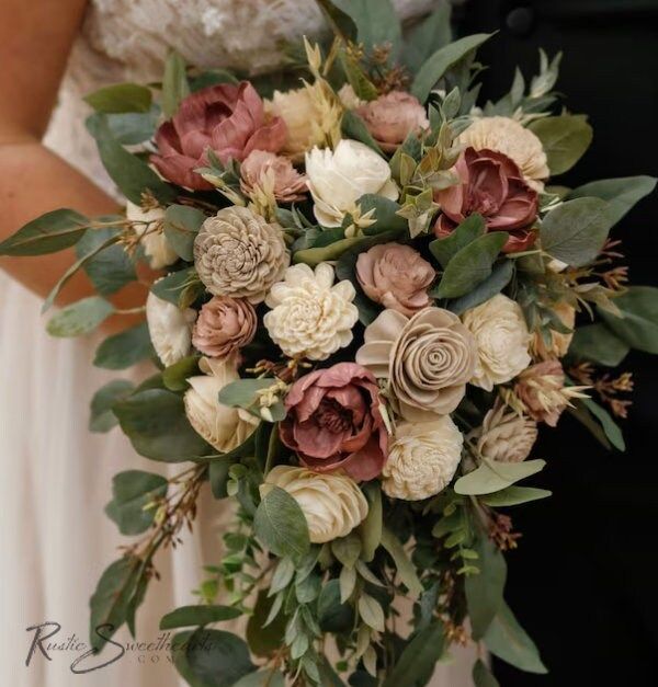 a bridal holding a bouquet of flowers and greenery