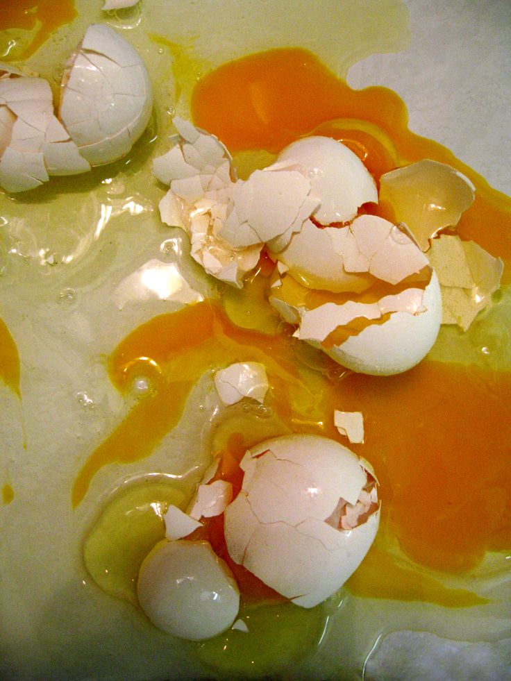 some eggs are sitting in an orange sauce on a white tablecloth with yellow and green dye