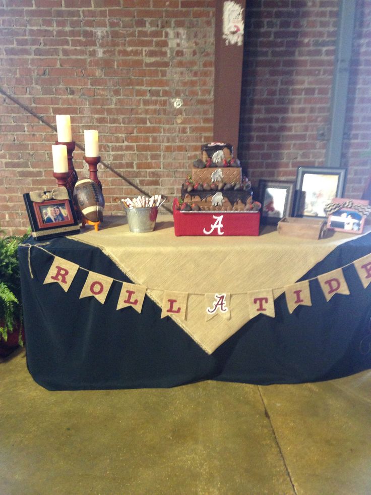 a table that has some pictures on it and a sign with the letters roll tide