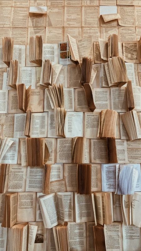 many open books are stacked on top of each other in the shape of a wall