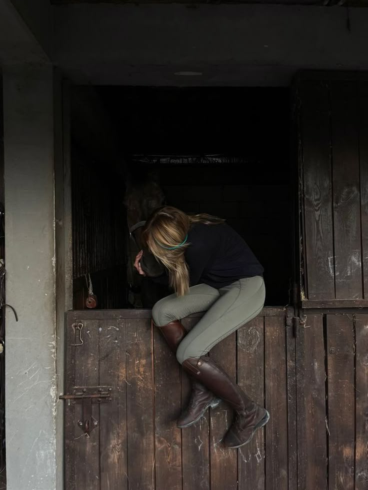 a woman leaning on the side of a wooden door