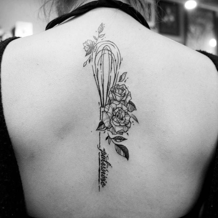 the back of a woman's shoulder with flowers and arrows on her left side