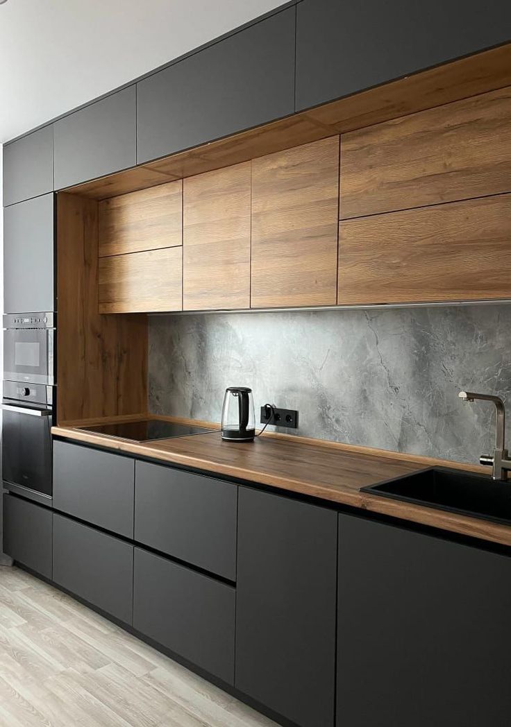 a modern kitchen with black cabinets and wood counter tops, along with stainless steel appliances