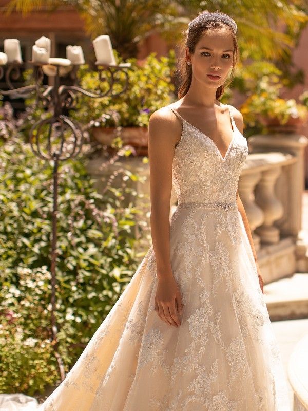 a woman in a wedding dress posing for the camera with her hand on her hip