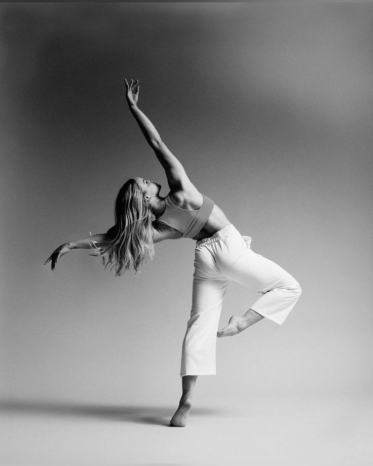 black and white photograph of a woman doing a dance move with her arms stretched out