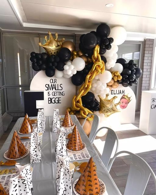 a table topped with lots of black and white balloons