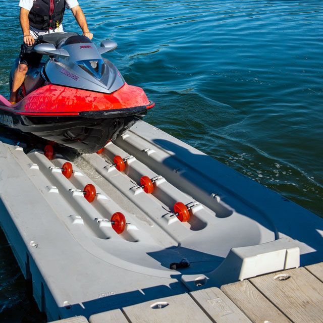 a man standing next to a red and black jet ski on top of a body of water