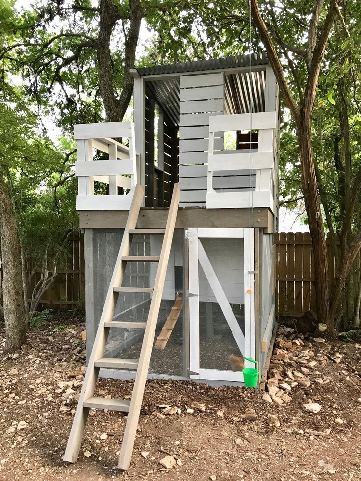 a chicken coop with stairs leading up to the roof