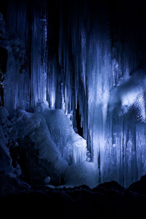 an ice cave with icicles hanging from it's walls and water flowing down the side