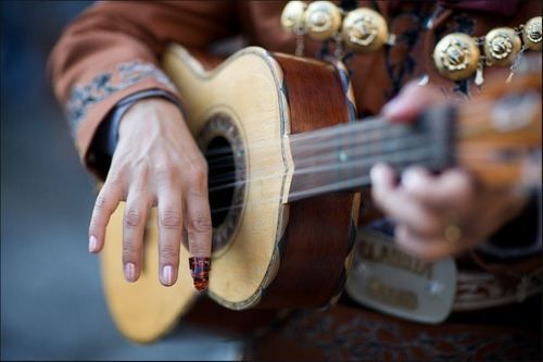 a person playing an acoustic guitar with their hands