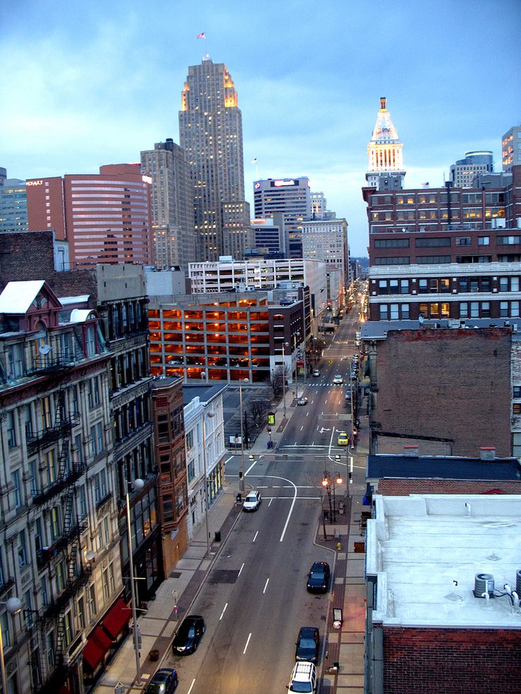 a city street filled with lots of traffic next to tall buildings and large skyscrapers