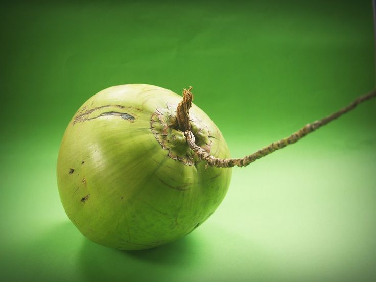 an onion sitting on top of a green surface next to a string that has been wrapped around it