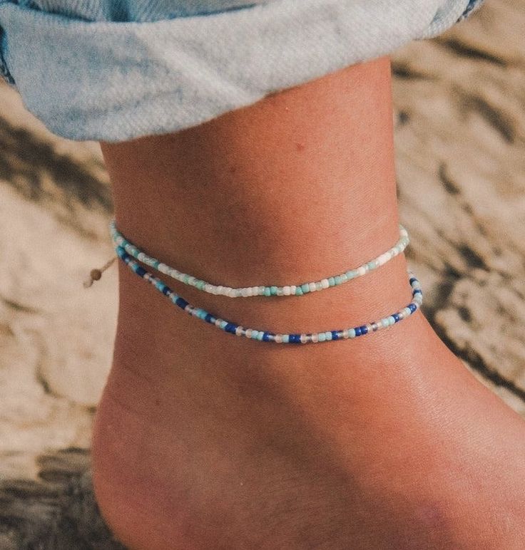 a woman's foot wearing a blue and white beaded ankle bracelet