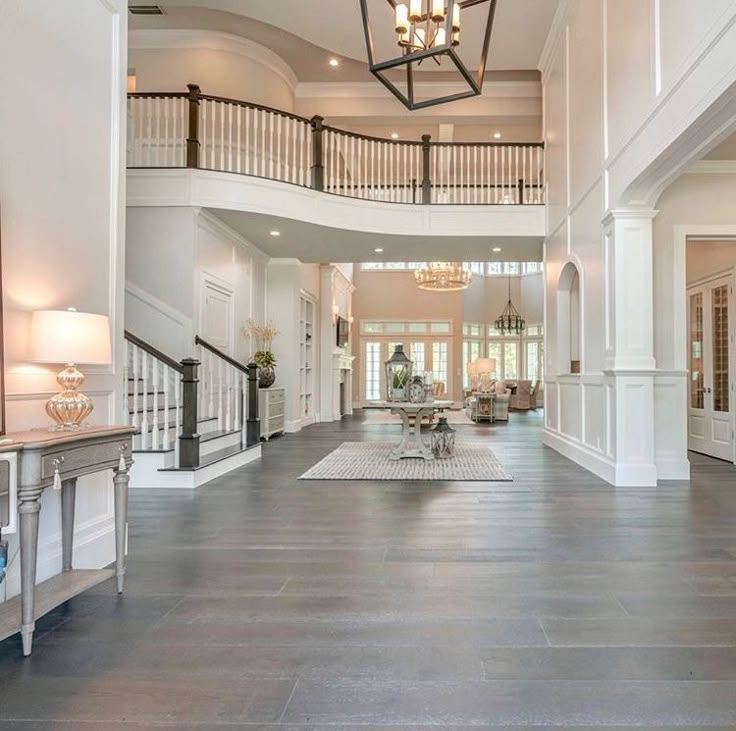 a large open floor plan with high ceilings and chandeliers on the second story