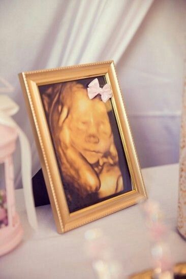 a framed photo with a bow on it sitting on a table next to other items