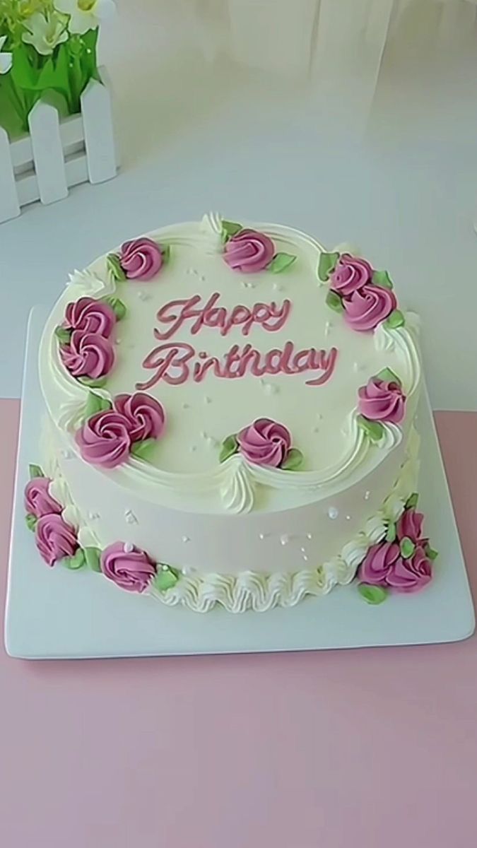 a white and pink birthday cake with roses on it