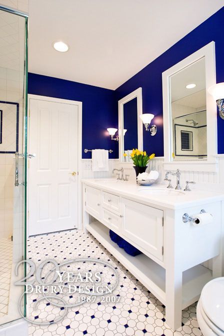 a bathroom with blue walls and white fixtures