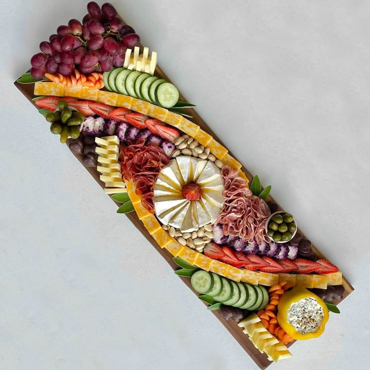 a fruit and vegetable platter is shown on a white surface