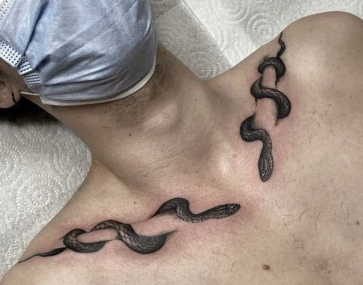 a man with a tattoo on his chest has a snake crawling through the stomach and back