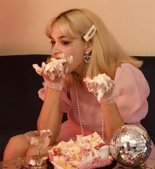 a woman sitting at a table eating cake