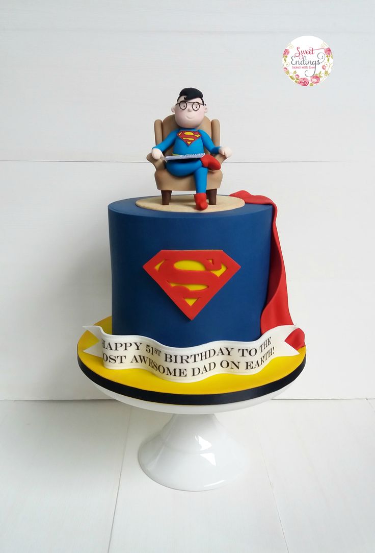 a birthday cake with a superman figure on top