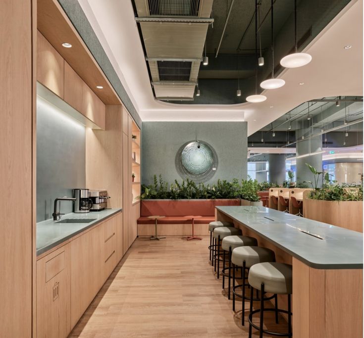 a long table with stools in front of it and plants on the wall behind it