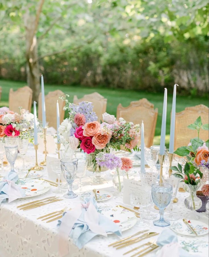 a table set with flowers and candles for a wedding reception in the park or garden