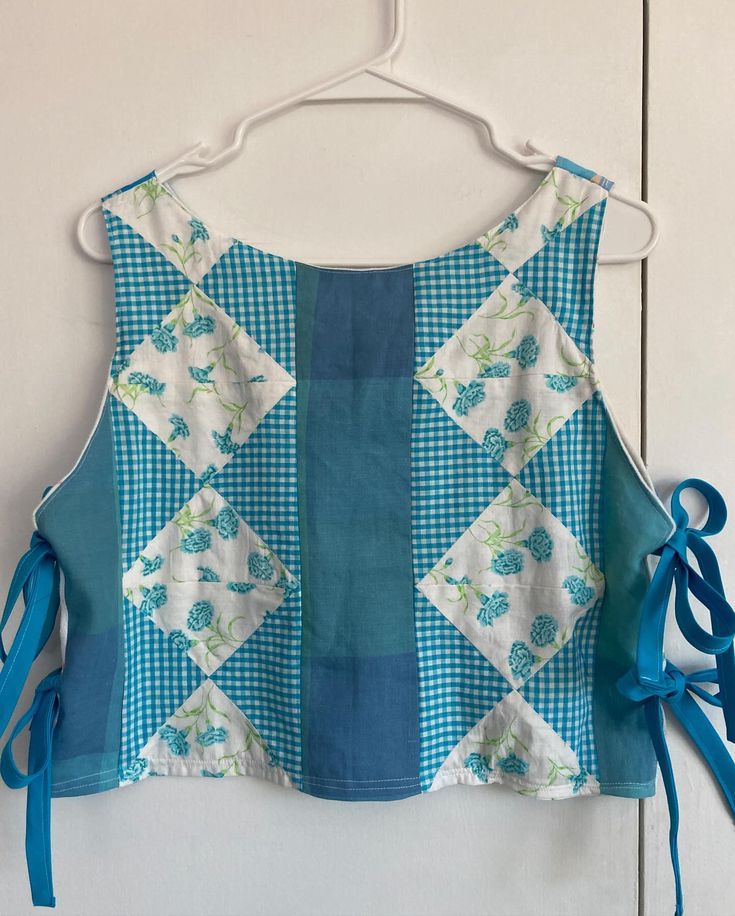 a blue and white top hanging on a wall